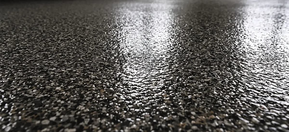 A close-up of a durable polyaspartic quartz flake floor coating showing high-gloss finish and texture