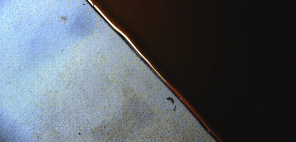 A close-up view of a smooth, glossy epoxy resin coating covering a textured concrete surface.