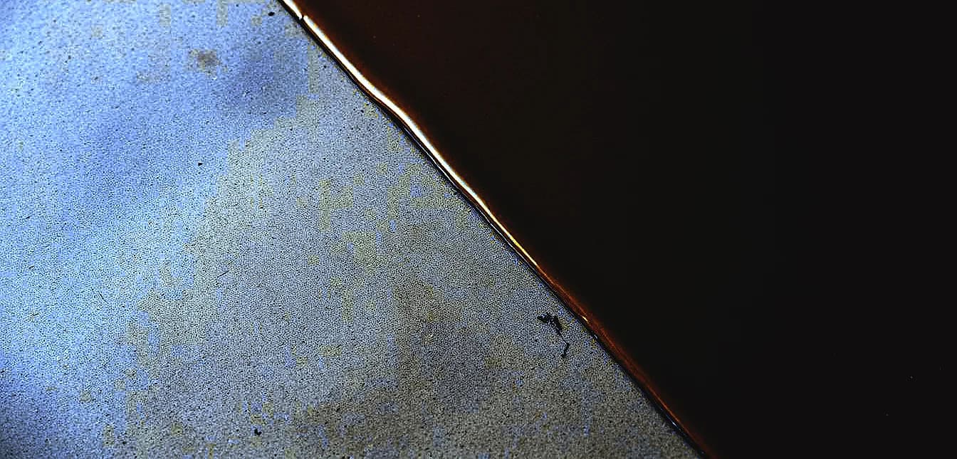 A close-up view of a smooth, glossy epoxy resin coating covering a textured concrete surface.