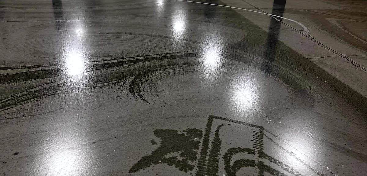 A durable industrial surface with a glossy, seamless epoxy coating. The floor is evenly lit, showcasing the smooth, reflective texture.