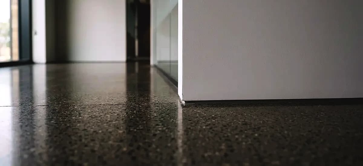Close up of a perfectly blended polished concrete edge meeting a commercial wall