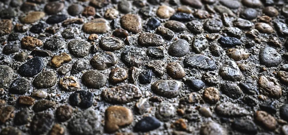 Close-up of exposed aggregate concrete showing different stone sizes and distributions affecting diamond tool wear