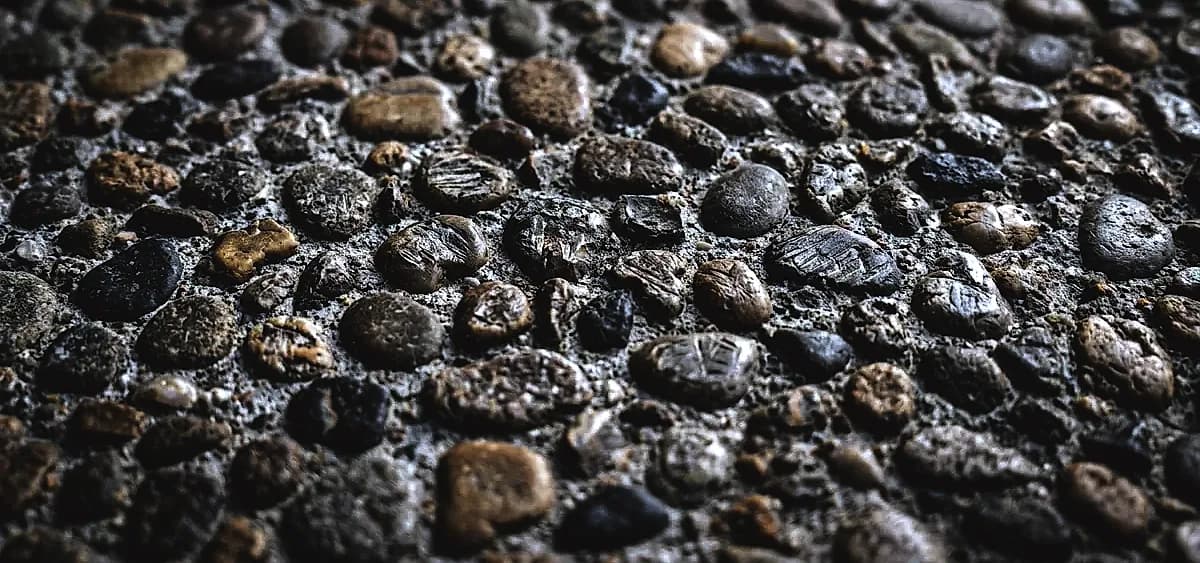 Close-up of exposed aggregate concrete showing different stone sizes and distributions affecting diamond tool wear
