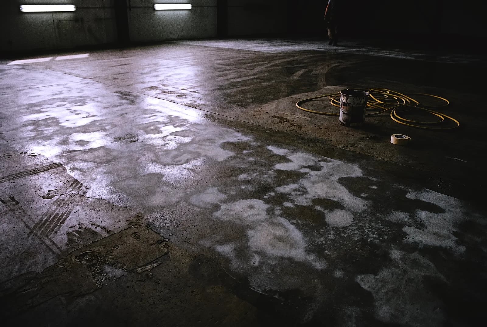A cured coating gone cloudy and blotchy across a warehouse floor