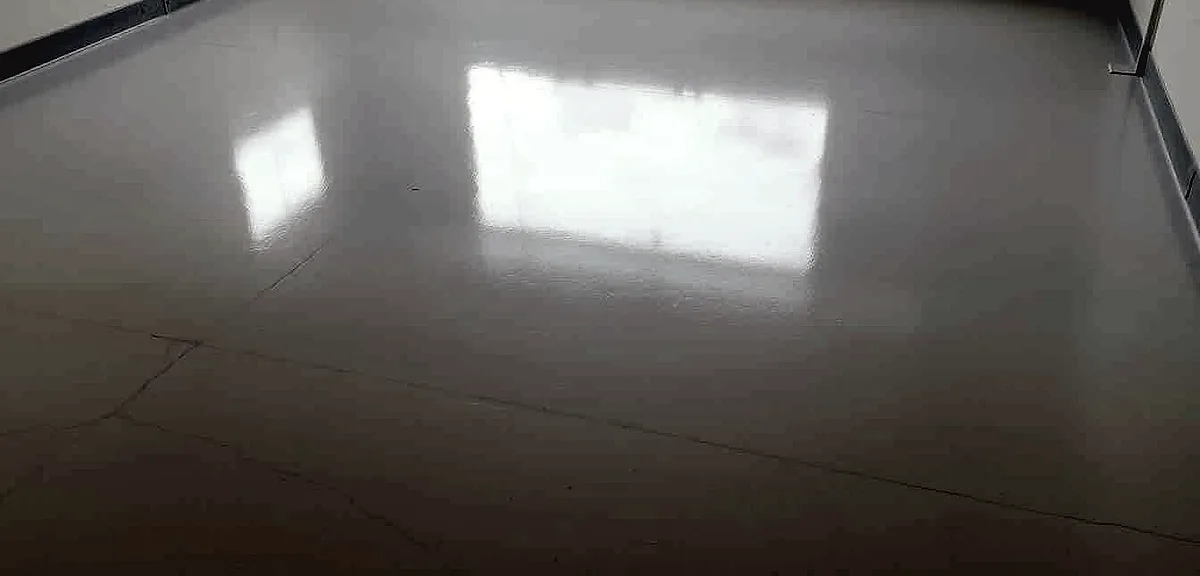An epoxy-coated garage floor glistens under soft, diffused lighting, the surface freshly dried and smooth.