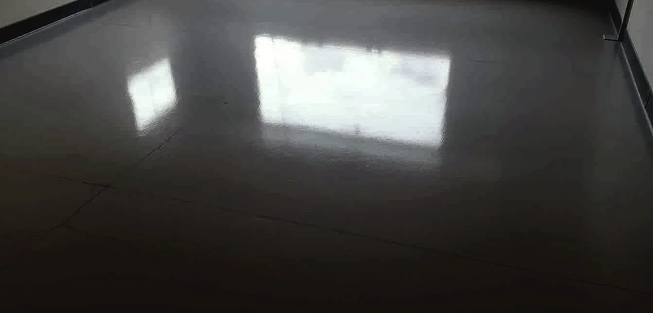An epoxy-coated garage floor glistens under soft, diffused lighting, the surface freshly dried and smooth.