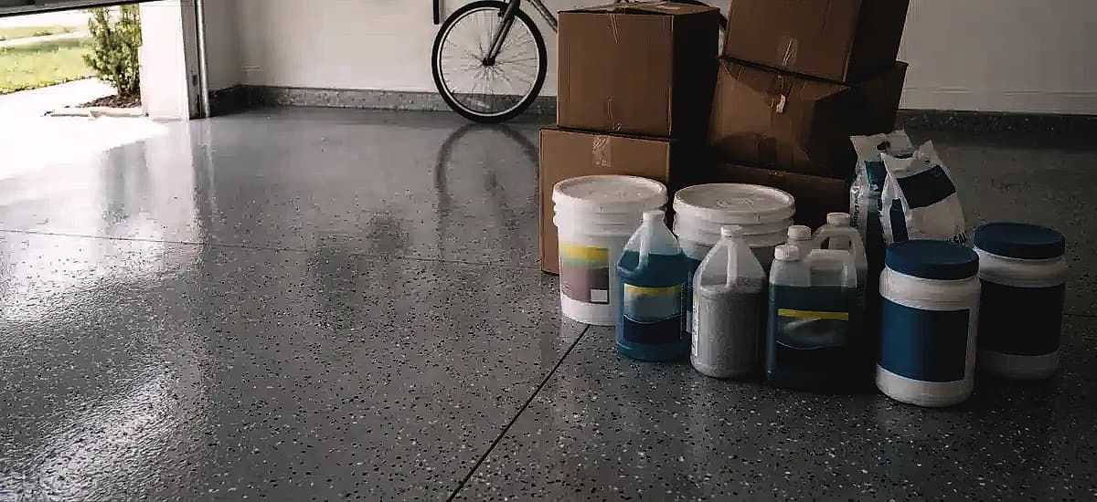 Improperly stored pool chemicals and cardboard boxes on a coated garage floor in Fort Lauderdale