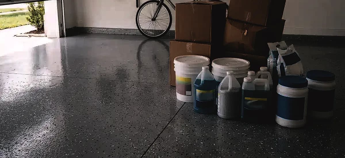 Improperly stored pool chemicals and cardboard boxes on a coated garage floor in Fort Lauderdale