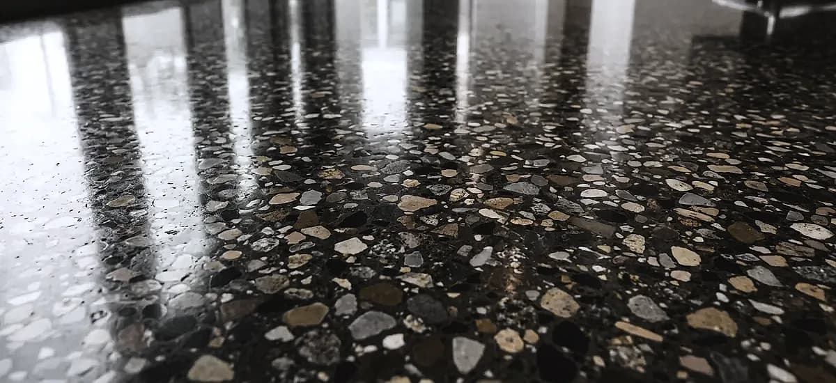 Close up of a Class D large aggregate polished concrete floor showing terrazzo style stone exposure and high gloss reflection