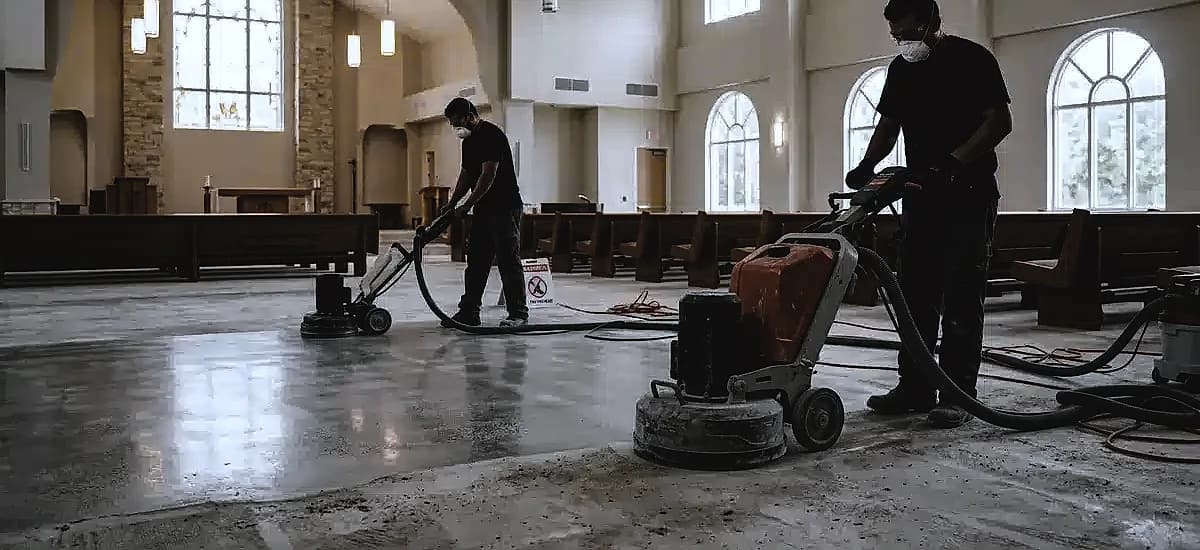 Contractors using planetary grinders during the concrete polishing process inside a South Florida religious facility