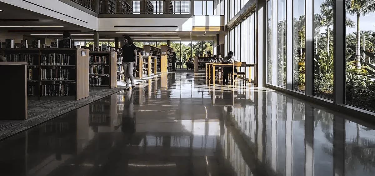 A brightly lit South Florida public library featuring high-gloss polished concrete floors that reflect natural sunlight