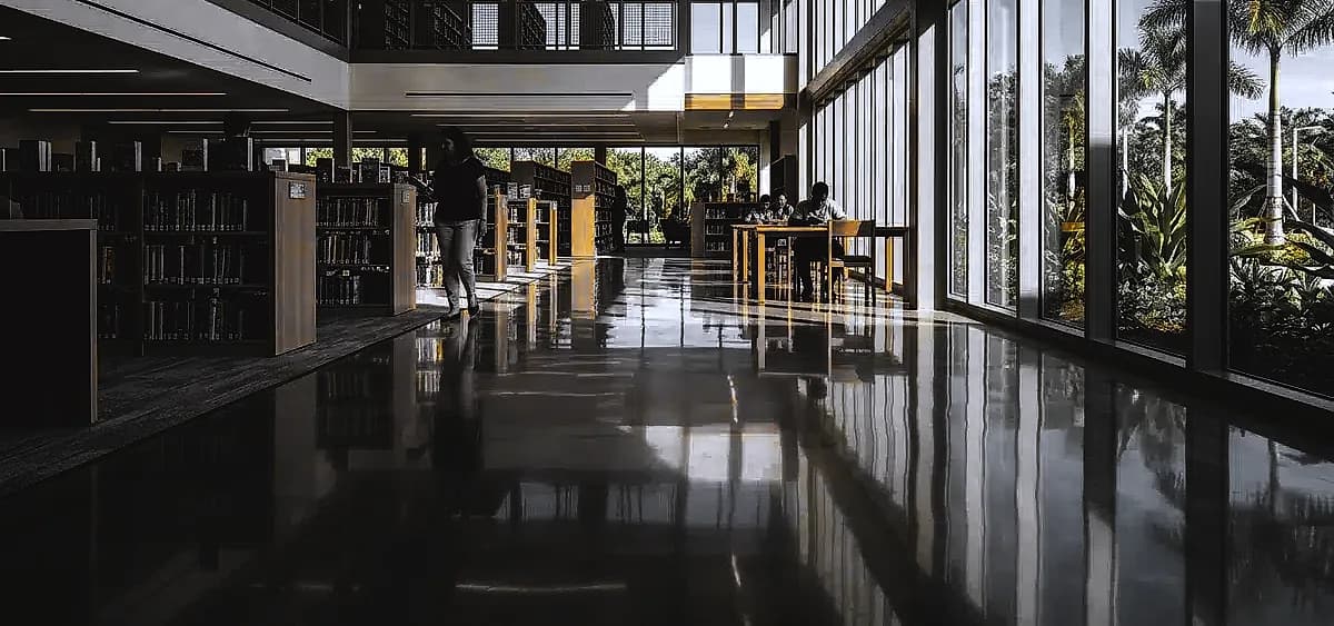 A brightly lit South Florida public library featuring high-gloss polished concrete floors that reflect natural sunlight