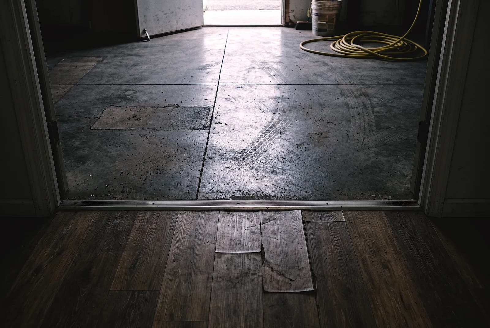 Vinyl plank meeting a coated concrete floor at a doorway threshold