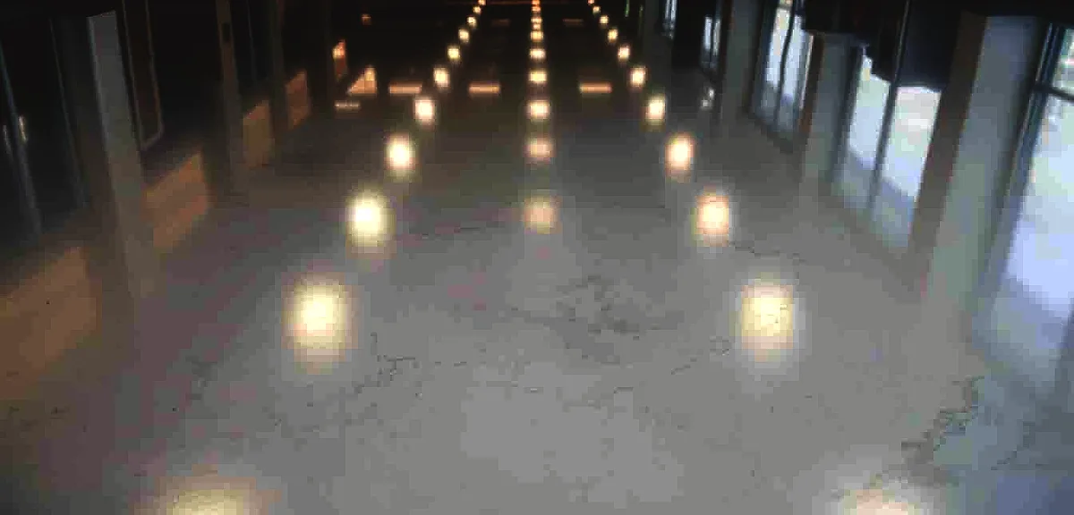 Detailed close-up of a pristine, glossy epoxy resin floor in a modern, well-lit commercial or industrial space.