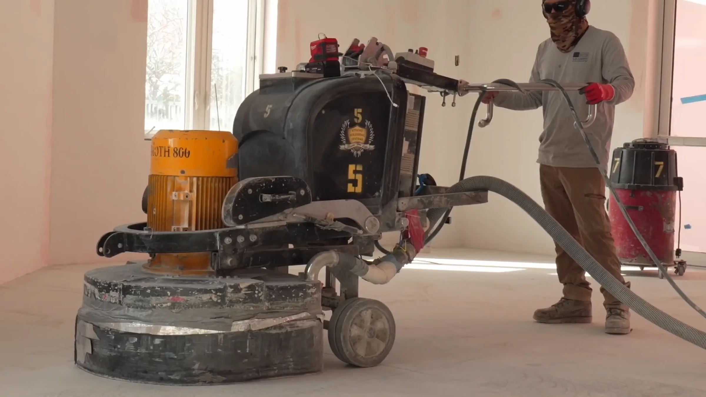 A floor grinder working across a concrete slab
