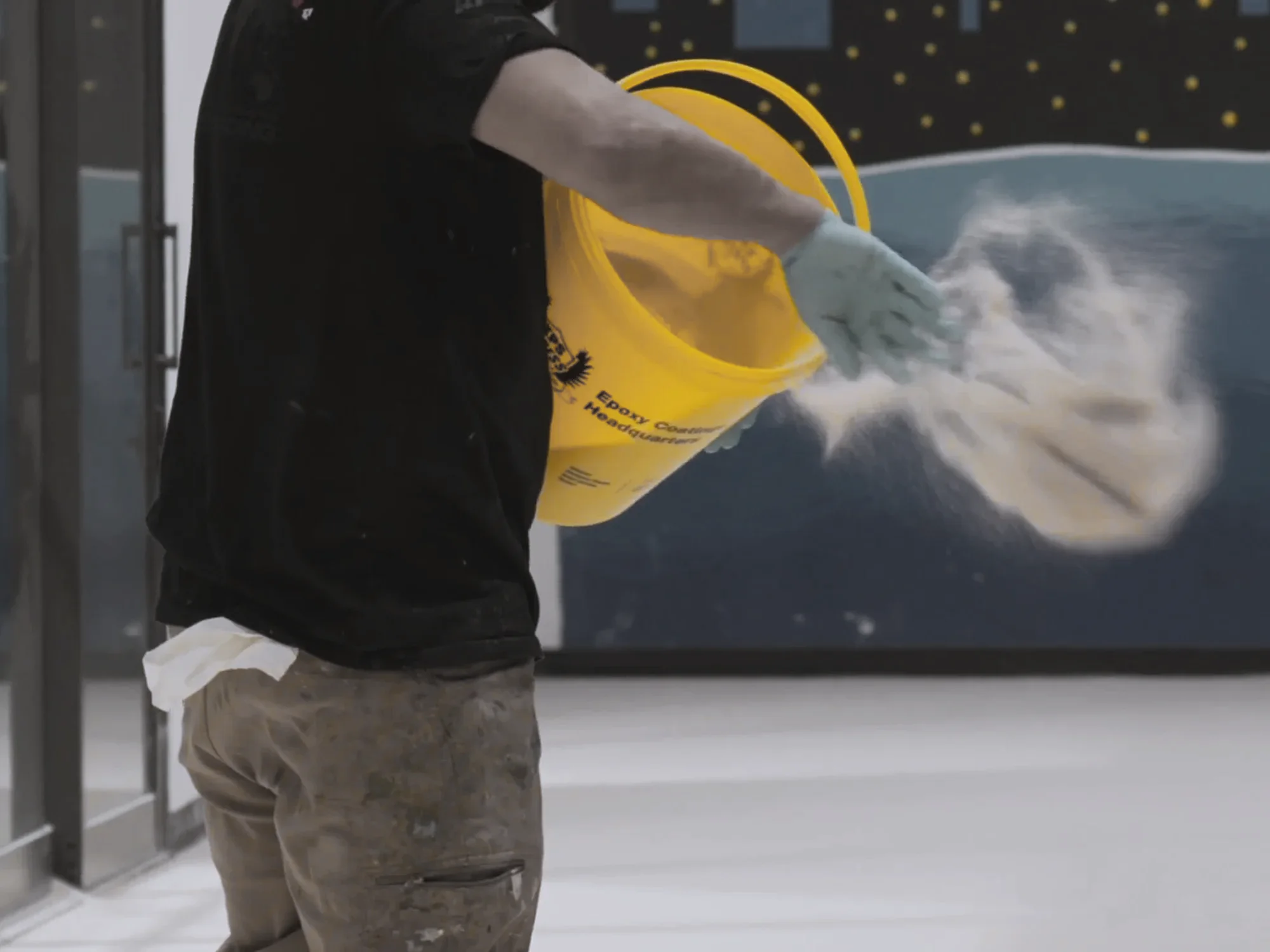 Crew member broadcasting flake from a branded Xtreme Polishing Systems bucket