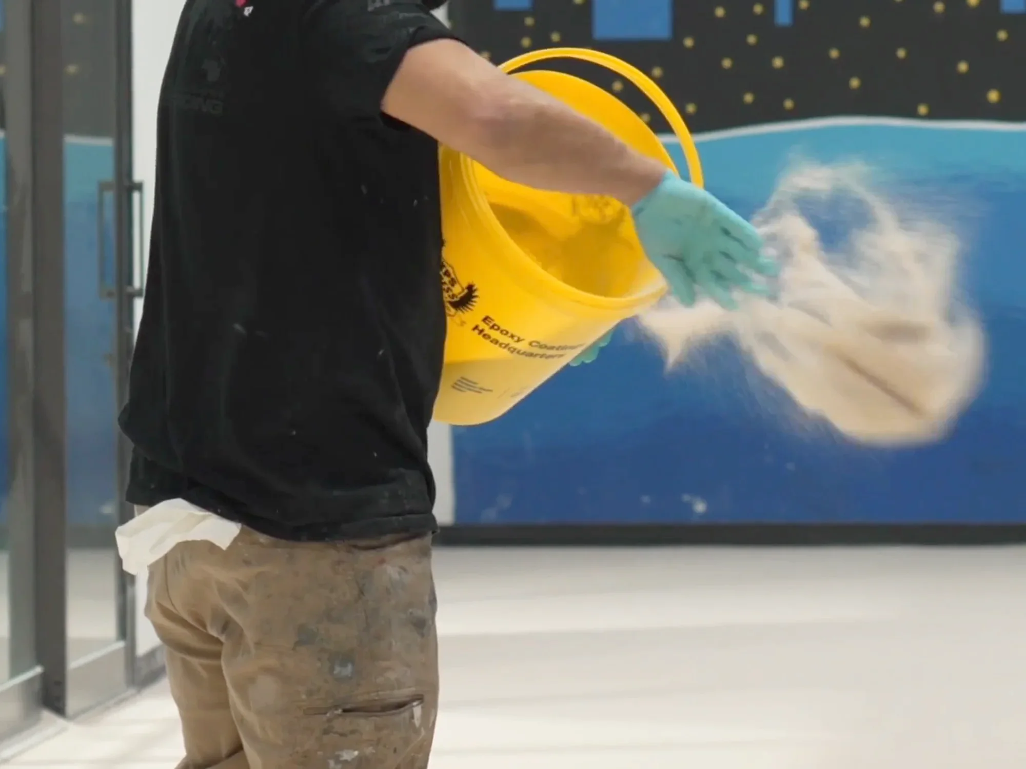 Crew member broadcasting flake from a branded Xtreme Polishing Systems bucket