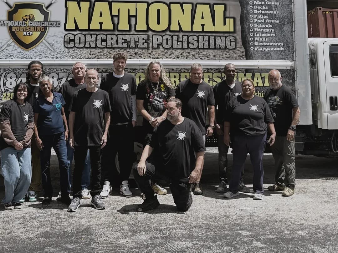 The crew standing in front of the National Concrete Polishing box truck outside the warehouse