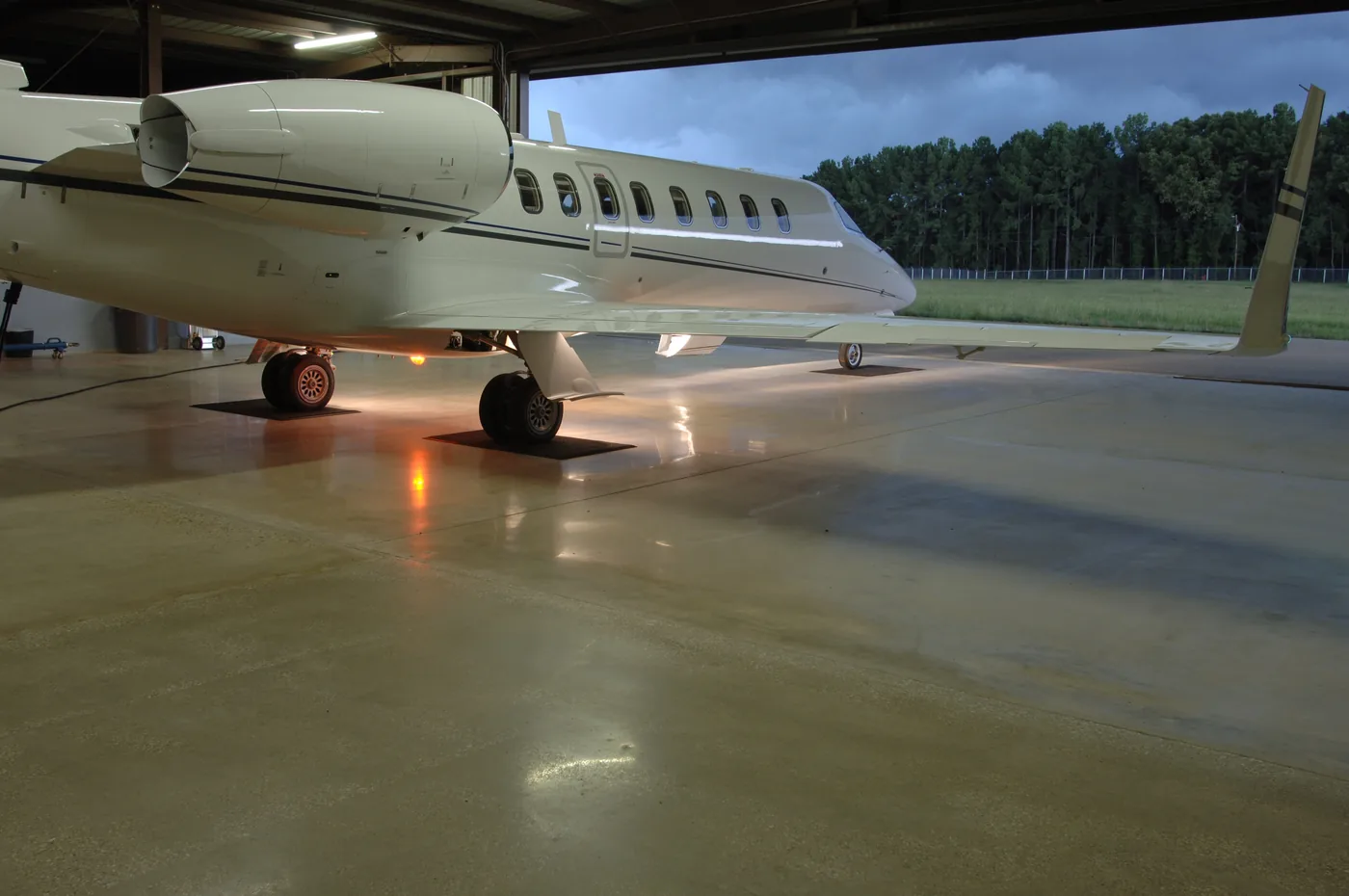 Business jet parked on a polished concrete hangar floor