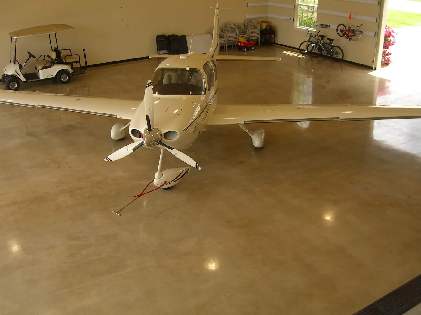 Small aircraft on a stained, polished concrete hangar floor