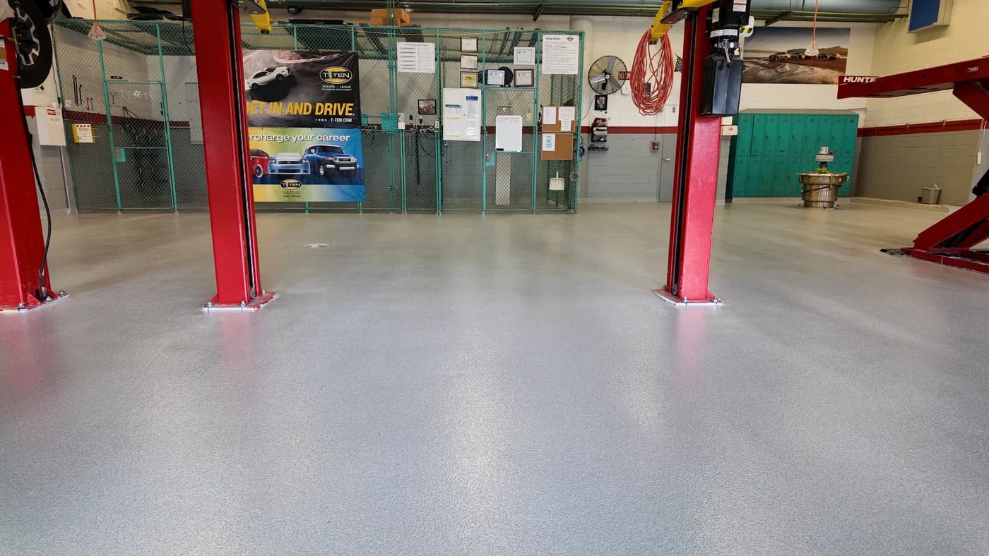 Quartz epoxy floor in a vehicle service bay with red lifts