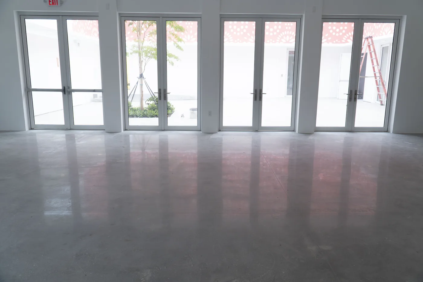 Polished concrete floor in a bright open space with French doors