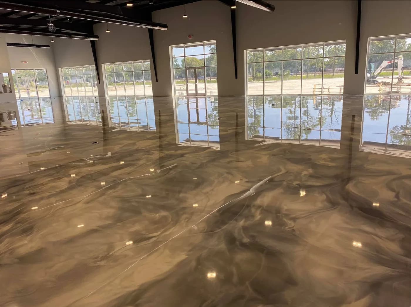 Bronze metallic epoxy floor reflecting a wall of tall windows