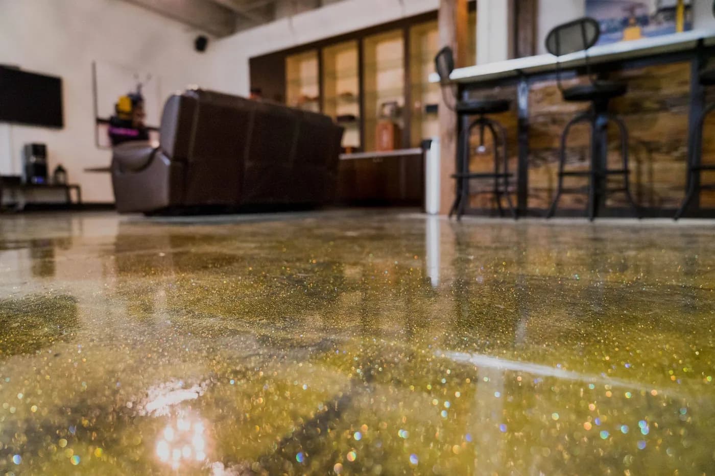 Gold glitter epoxy floor in a lounge with bar stools