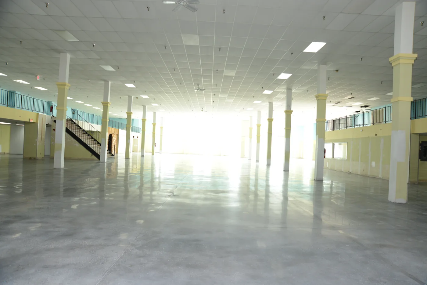 Polished concrete floor in a large open hall lined with columns