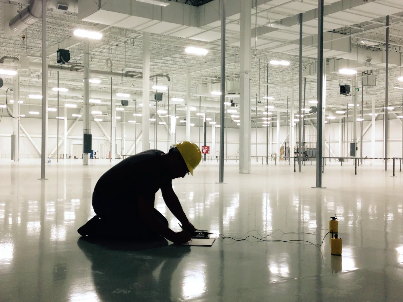 Installer checking a freshly coated warehouse floor