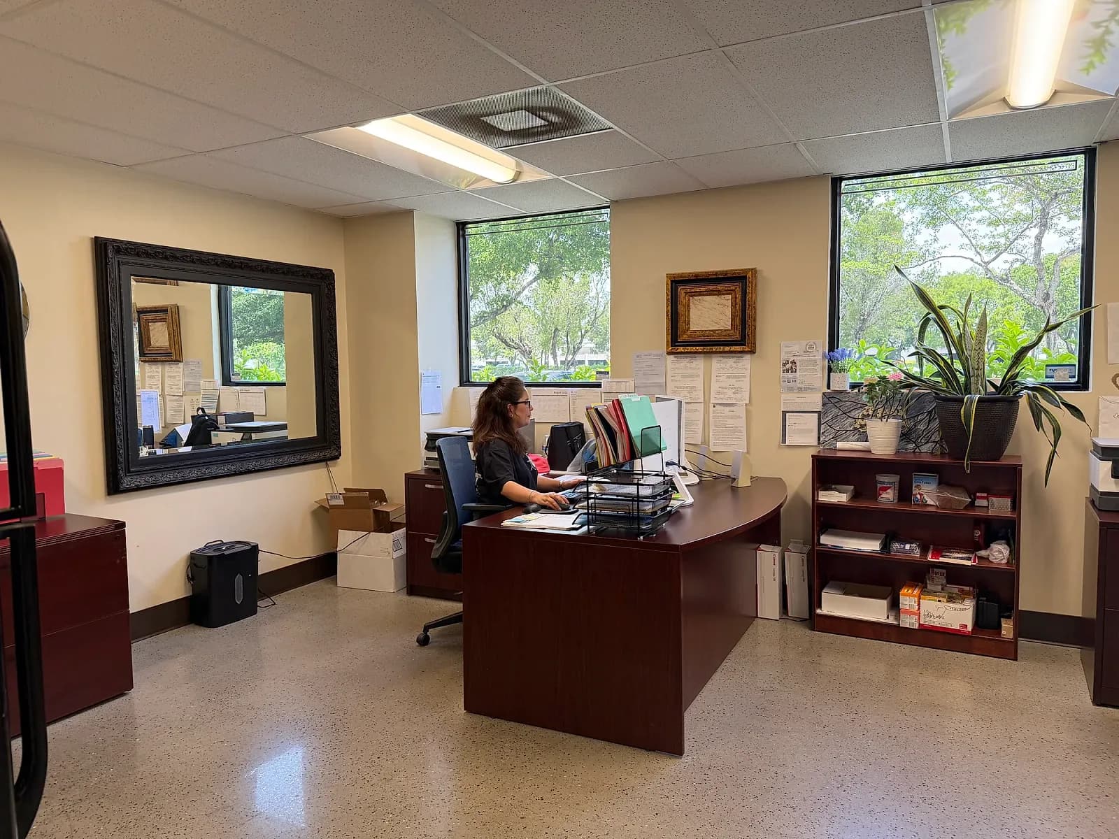 The NCP office front desk with paperwork trays and a polished concrete floor, daylight through the windows