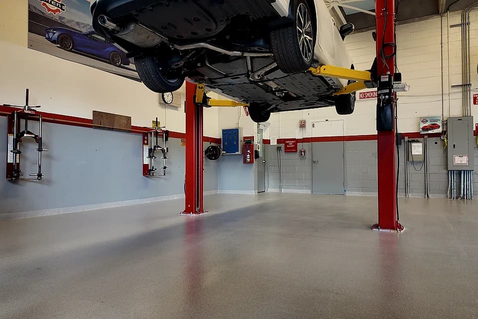 Technical school automotive bays in Miami after installation: finished quartz floor under the vehicle lifts