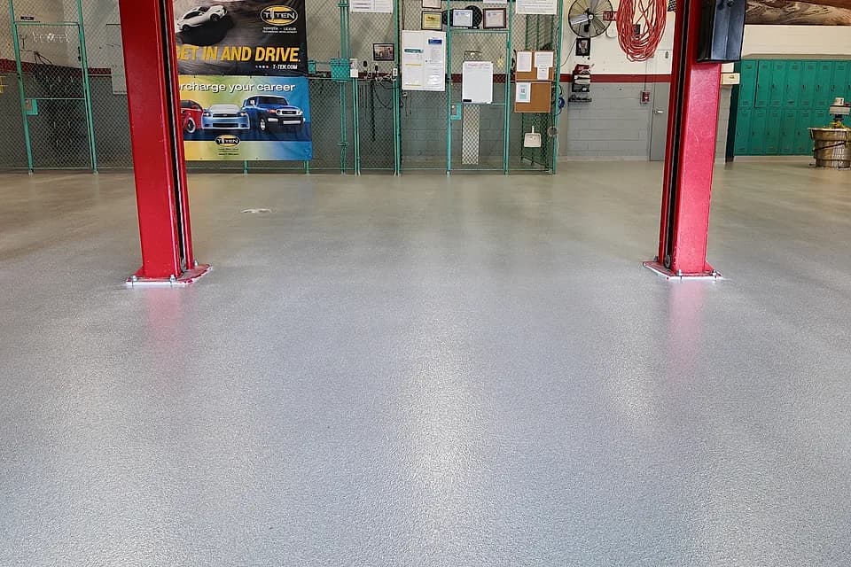 Technical school automotive bays in Miami after installation: finished quartz floor under the vehicle lifts