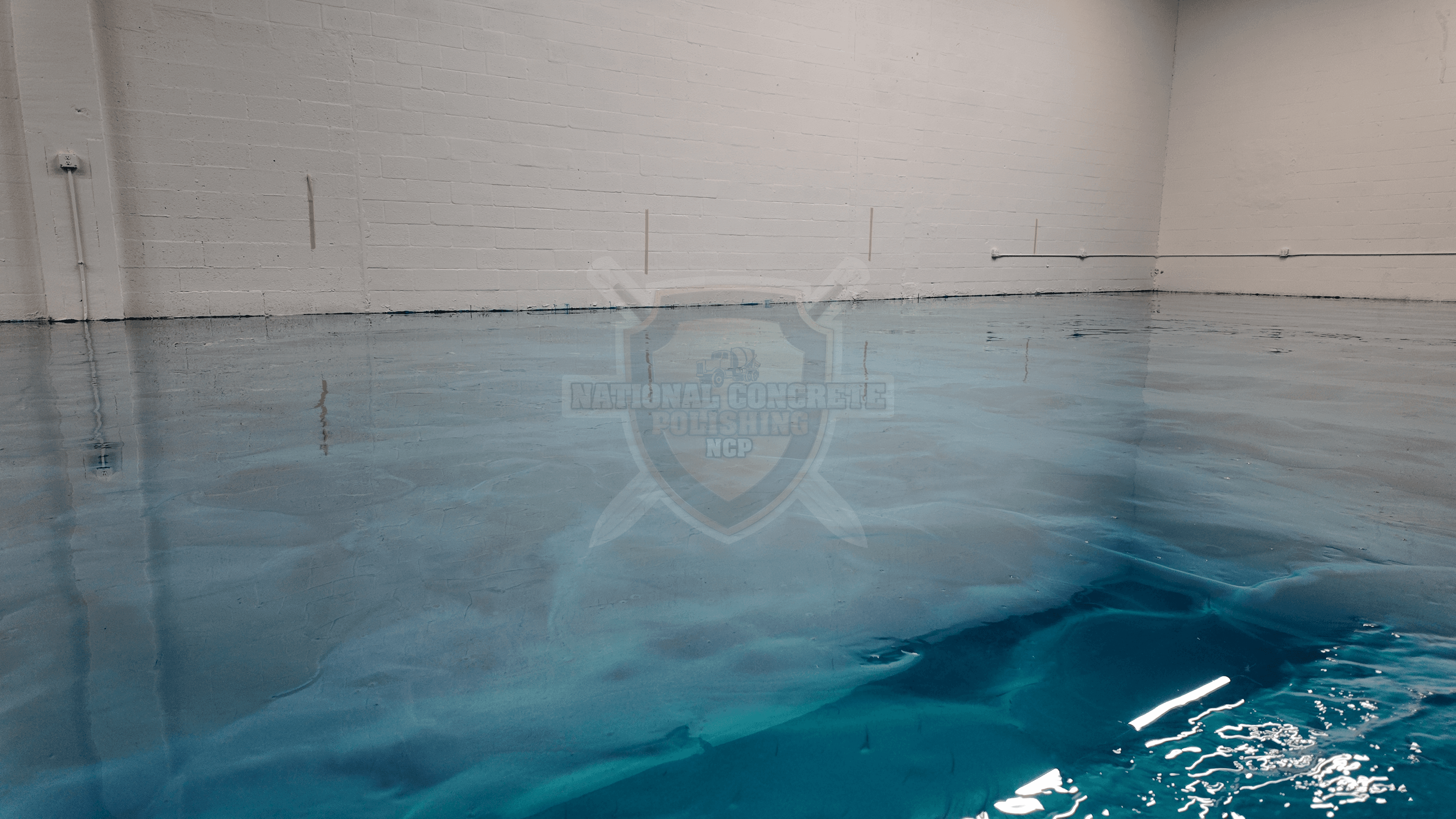Metallic blue epoxy resin installed in a warehouse setting.