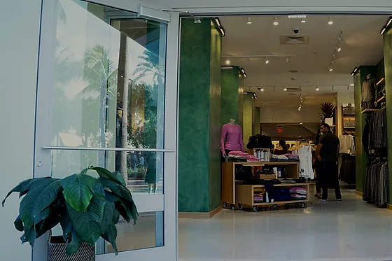 The store entrance seen from the pavement, the pale polished floor carrying through from the threshold into the sales floor