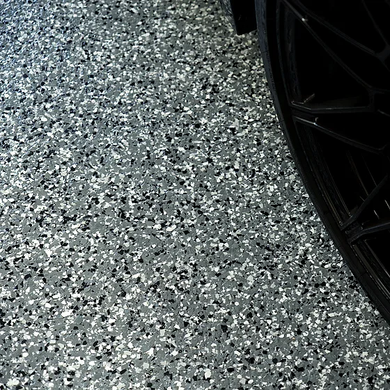 A close view of the flake surface, its gray, black and white chips reading sharply beside a wheel